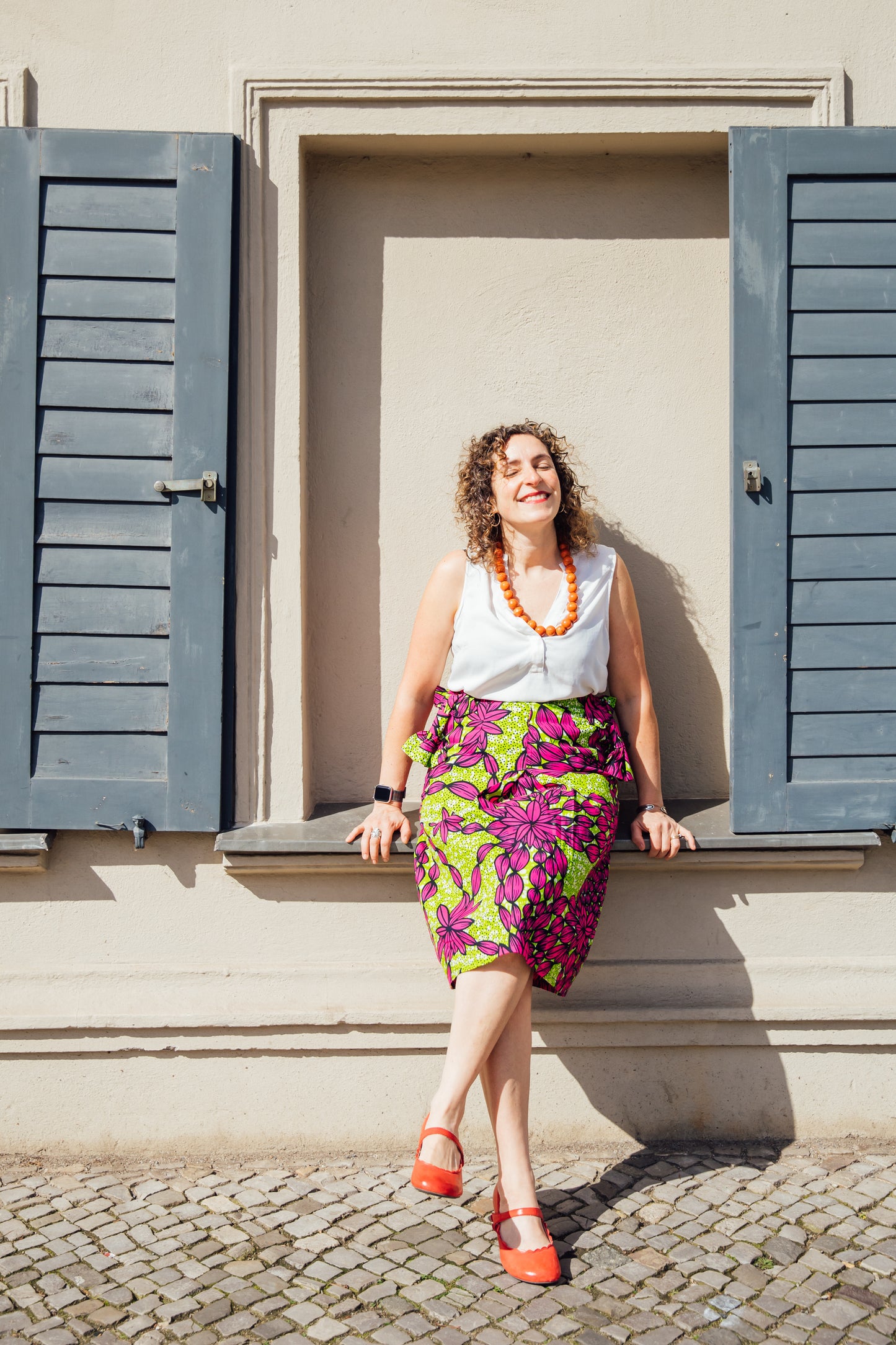 Grün-pinker Midirock mit Schleifen an den Taschen