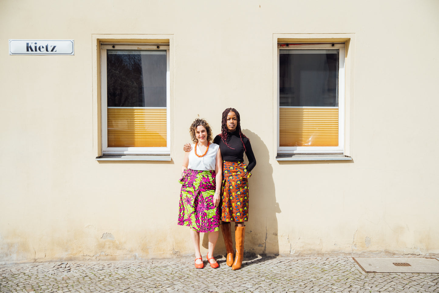 Brauner Midirock mit gelben und blauen Blätter und Schleifen an den Taschen