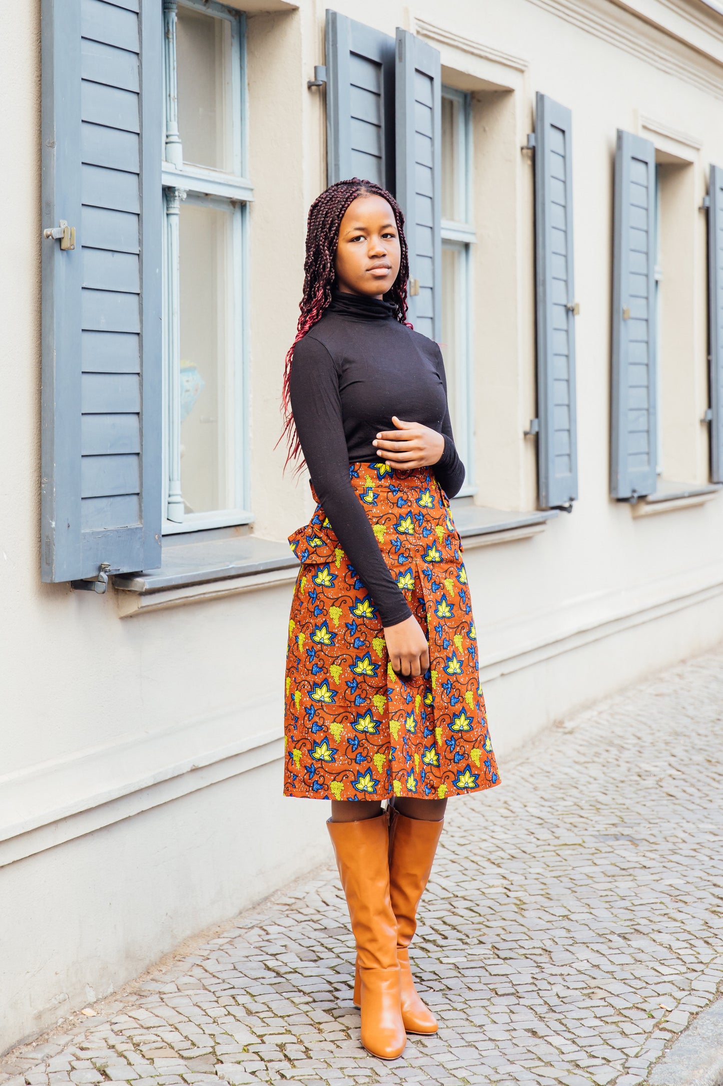 Brauner Midirock mit gelben und blauen Blätter und Schleifen an den Taschen